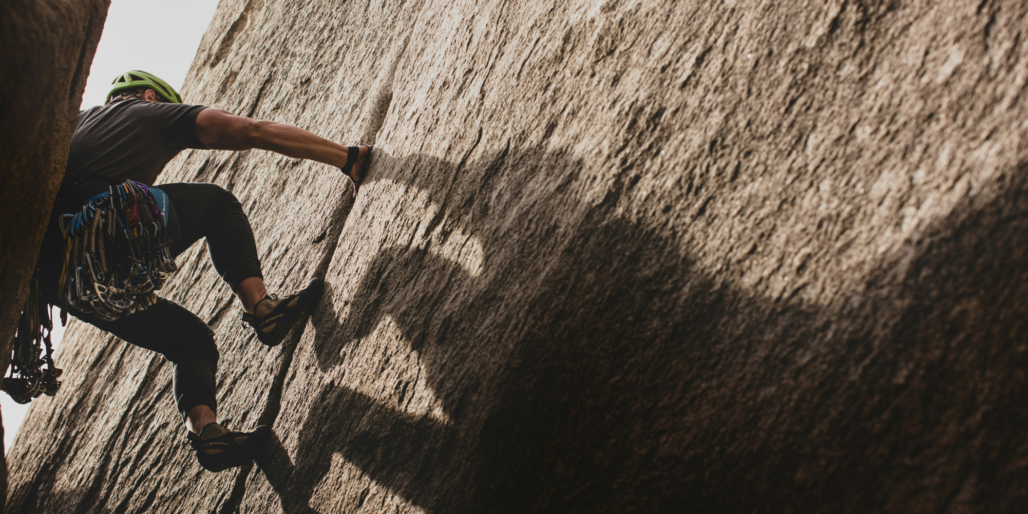 A person climbing a rock face, symbolizing overcoming financial challenges